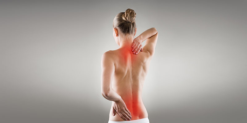 Frau mit markierten Schmerzpunkten/ Rückenmuskulatur